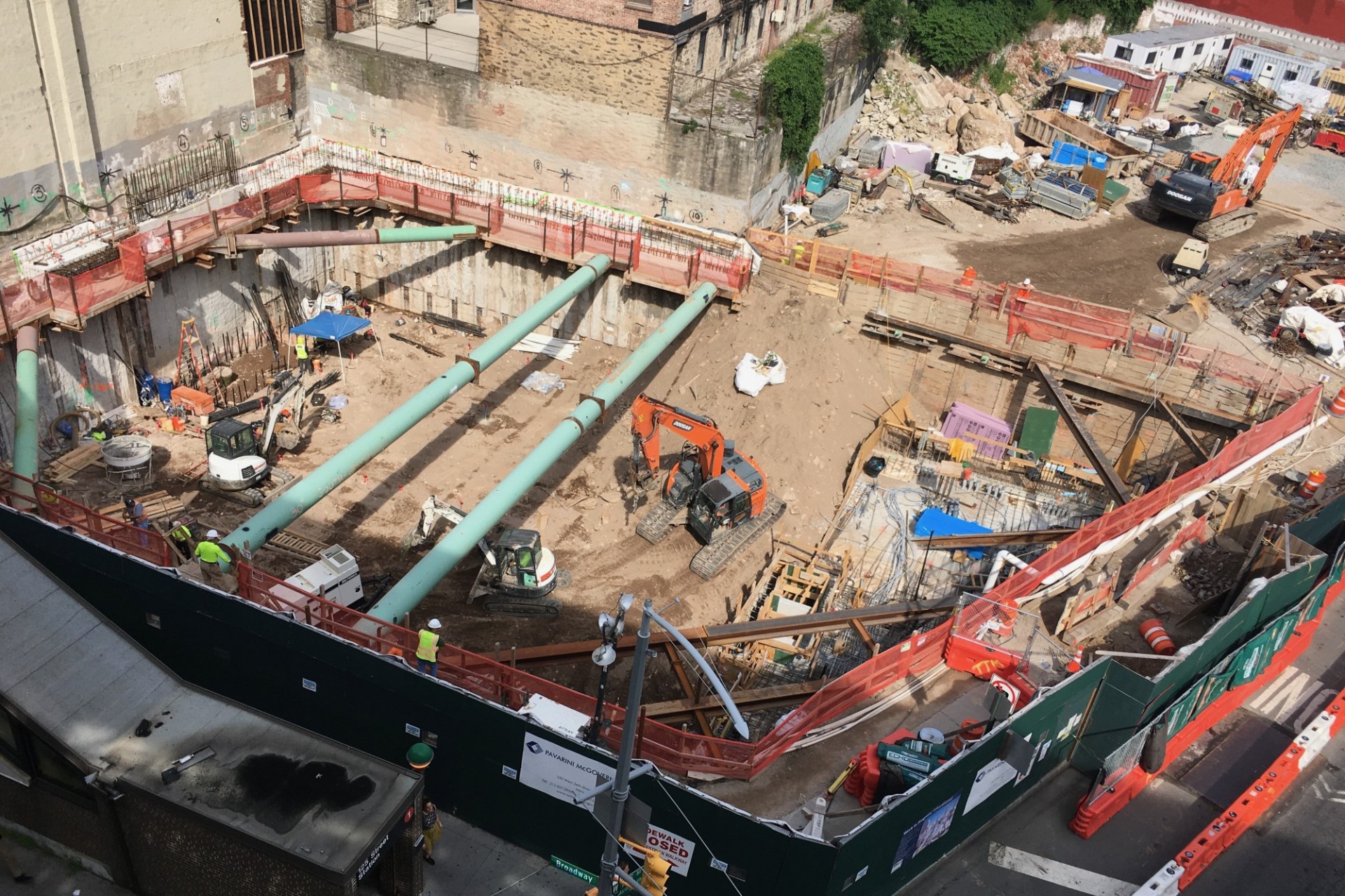 A view of the 600 W. 125th Street construction site with steel beams running across a dirt pit. 