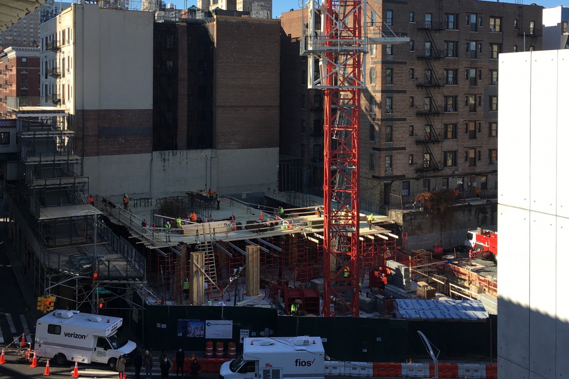 An aerial view of the 600 W. 125th Street construction site from the 125th Street subway, with a large red crane on the site.