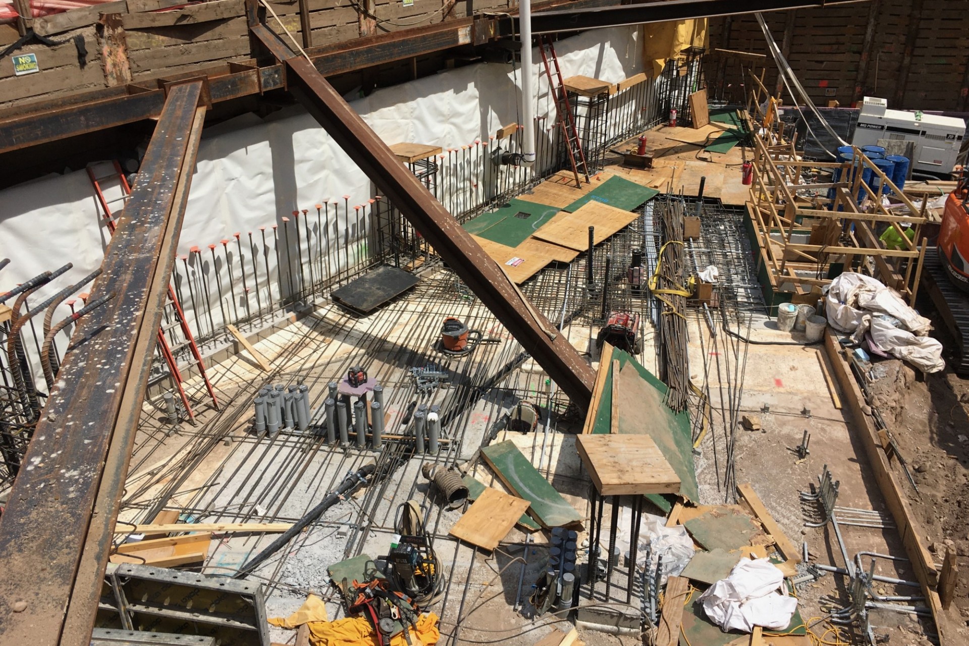 A view of the 600 W. 125th Street construction site with rebars along the perimeter of the northern portion of the site with steel beams overhead.