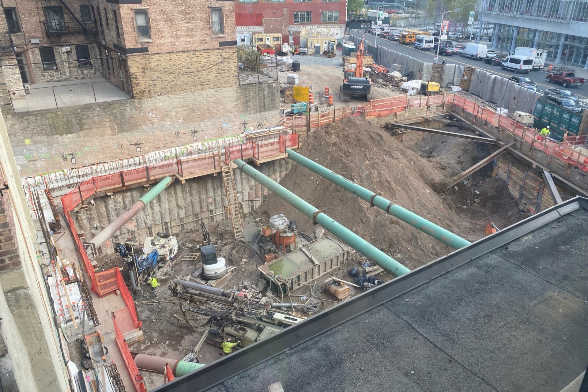 600 W. 125th Street construction site, looking west A view of the 600 W. 125th Street construction site with equipment and support pipes running across. Foundation work being performed on a construction site.