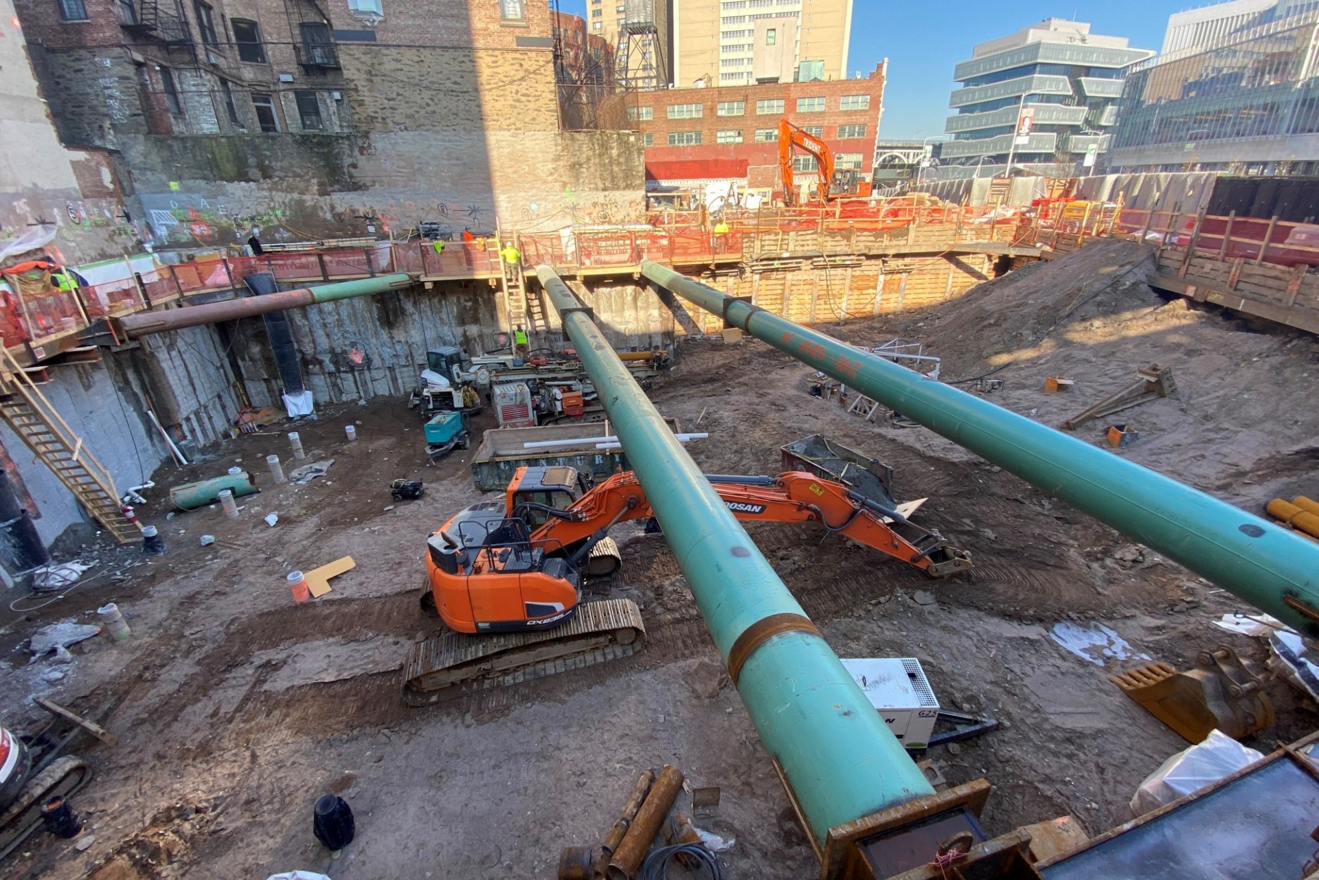 A view of the 600 W. 125th Street construction site with equipment and support pipes running across.