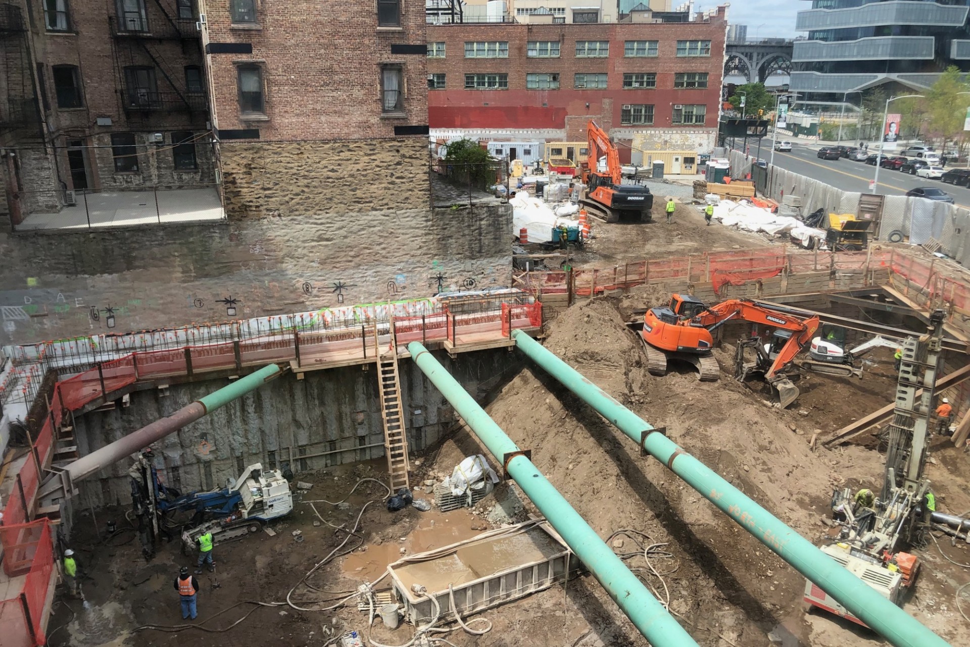 600 W. 125th Street construction site, looking west A view of the 600 W. 125th Street construction site with equipment and support pipes running across. Foundation work being performed on a construction site.