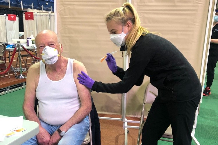 Jennifer Shahar vaccinates her father at the Armory