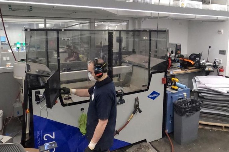 a man in a factory processing face shields