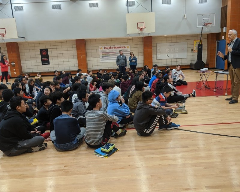 Professor Massamino speaking to Junior High School students in the school gymnasium 