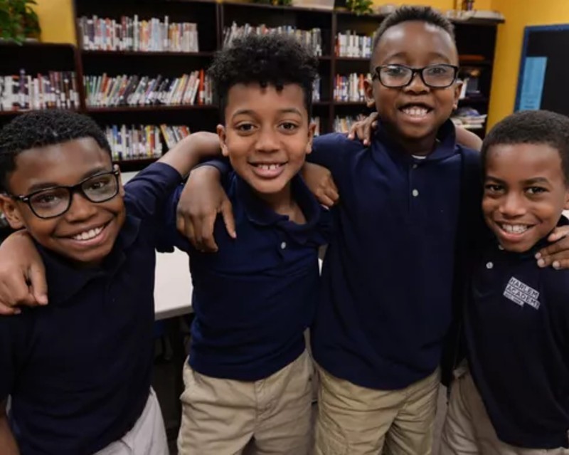 CCS Grantee: Harlem Academy four young children smiling for a group photo in school uniforms