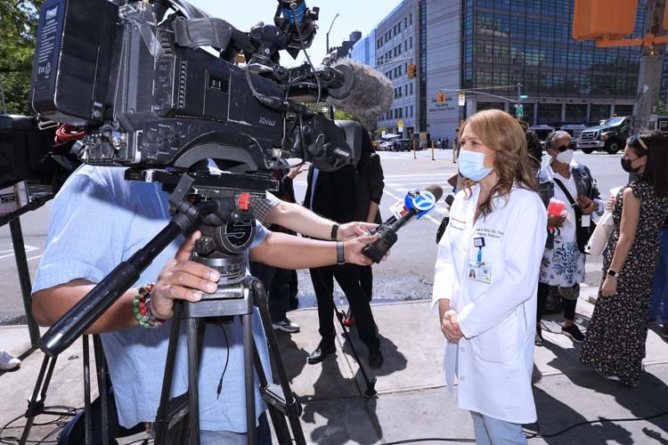 woman speaking to news camera