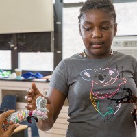 A girl reaches for a toy.