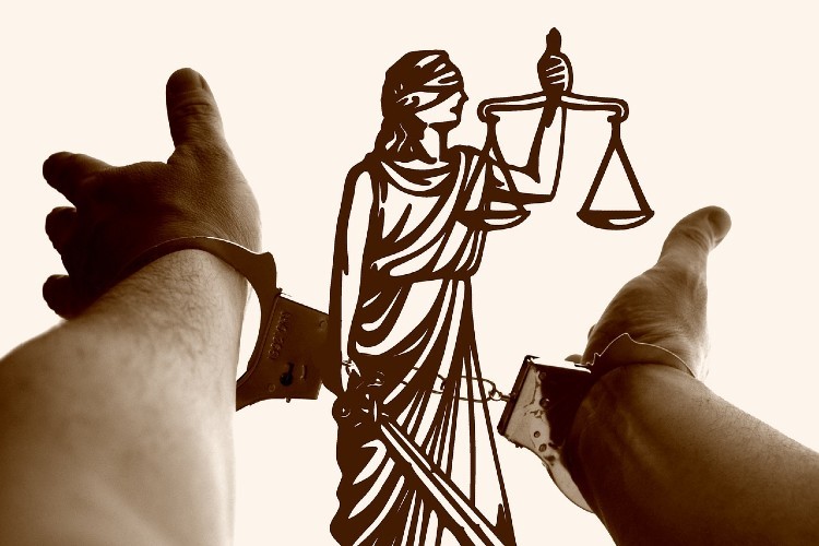 Reimagining the Future of Justice. Hands cuff reaching out to the scales of justice