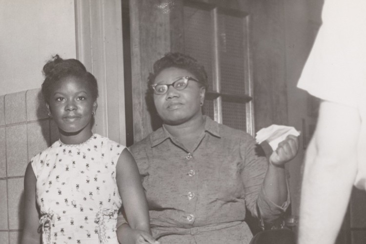 Mae Mallory and her daughter. Mallory, a civil rights activist in the 1950s and 60s, sought integrated education for New York City children and organized a boycott of schools that lasted months. Photo credit: Amsterdam News archive. Woman and daughter holding hands.