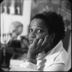 Michele Washington A woman in a white shirt rests her chin in her hand.