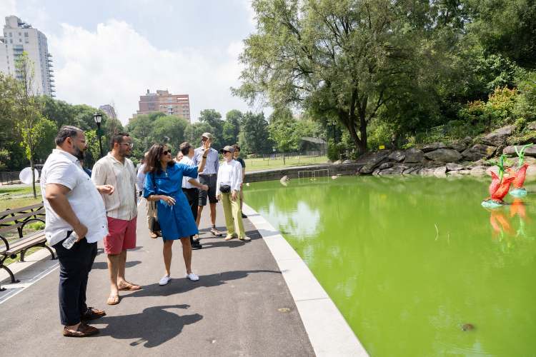 Manhattan Borough Commissioner of NYC Parks Anthony Perez, New York City Council Member Shaun Abreu, and Columbia University President Minouche Shafik observe the algae at the Morningside Park Pond. Photo credit: Diane Bondareff