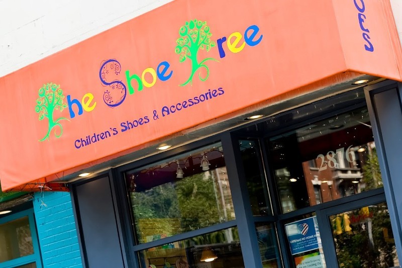 An orange awning with text saying "The Shoe Tree: Children's Shoes & Accessories."