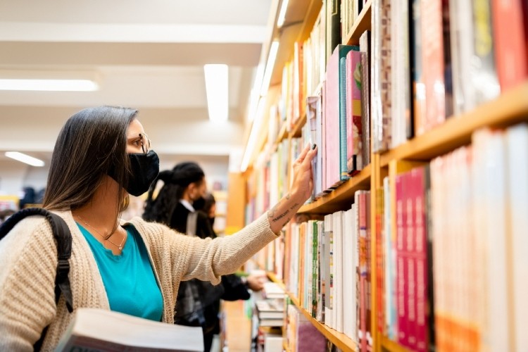 woman looking at books on a bookshelf
