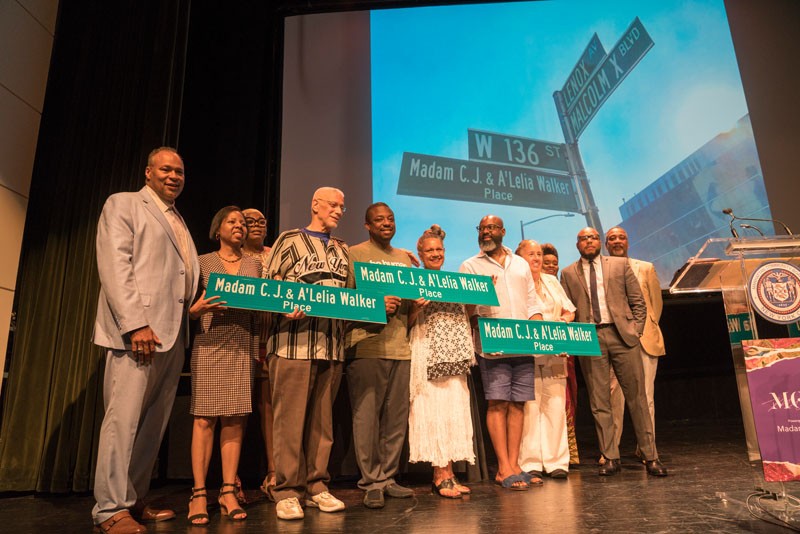 People gathered with street signs on stage. 