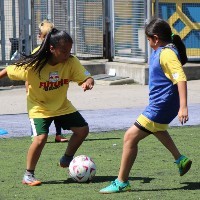 Two girls playing soccer.
