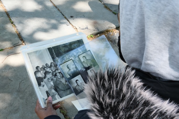 Plastic liners full of black and white pictures being held by a student in a hoodie.