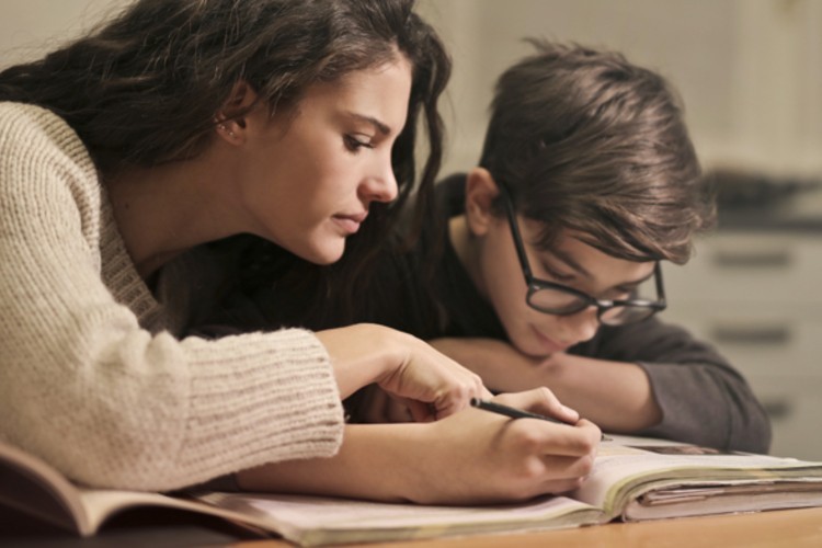 A girl and a boy studying from a textbook together.