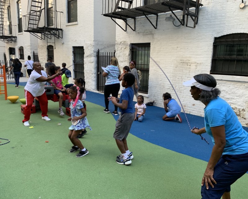 Adults and children jumping rope on playground