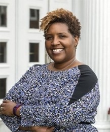 A woman with short hair smiles at the camera.