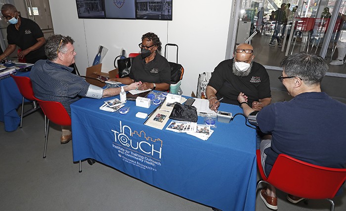 Two InTouch volunteers do blood pressure screenings in The Forum. 