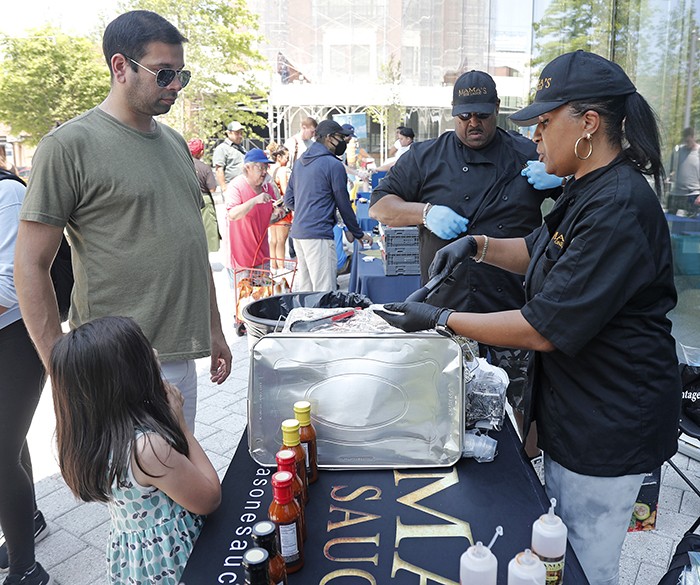 Mama's One Sauce, a Columbia-Harlem Small Business Development Center client, hands out samples to visitors. Photo by Lou Rocco. Mama's One Sauce hands out samples.