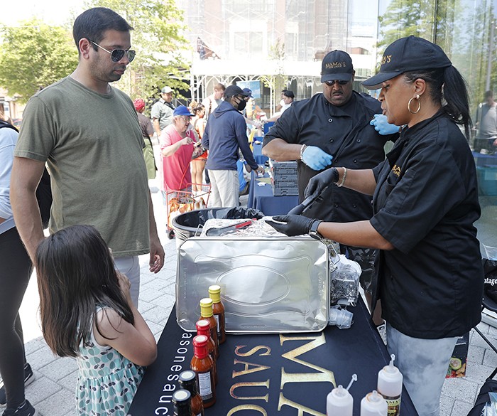 Mama's One Sauce hands out samples.