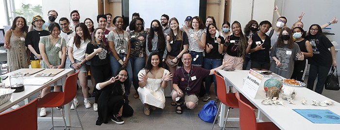 Saturday Science volunteers, including graduate students from Zuckerman Institute and Bio Bus, pose inside the Jerome L. Greene Science Center's Education Lab. Photo by Lou Rocco. A group of 20+ students stands inside the Education lab