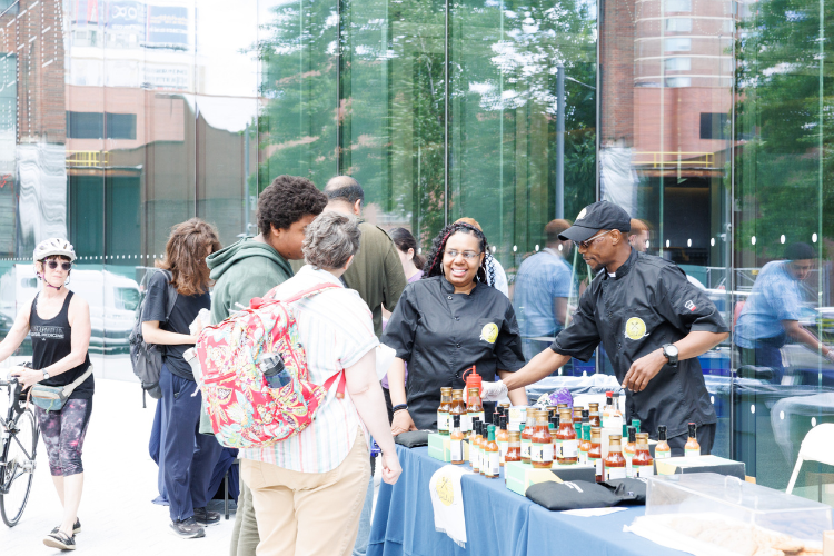 Manhattanville Community Day attendees sampling Chef Marshall's sauces. Photo credit: Sirin Samman