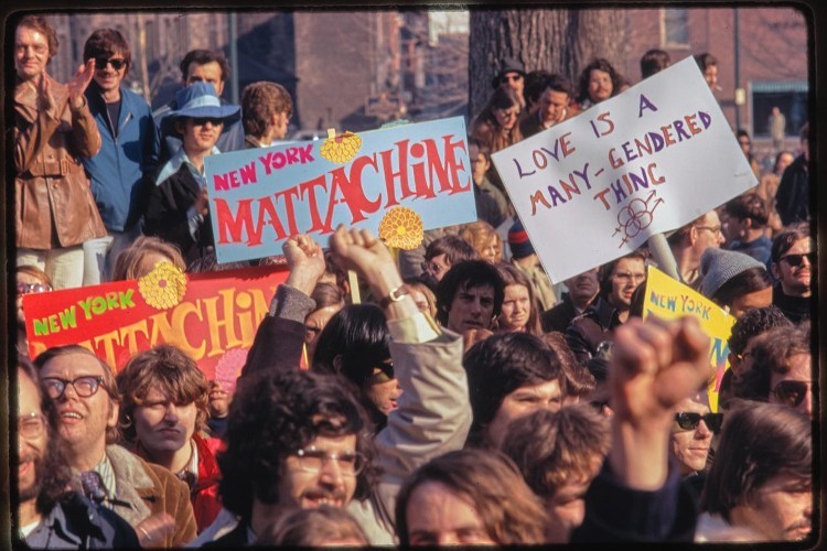 A historical photo of a Pride march with a variety of signs.