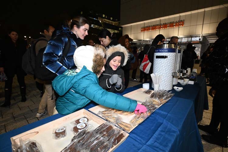 Children enjoy treats from Pabade Bakery ahead of the lighting of the trees on the plaza.