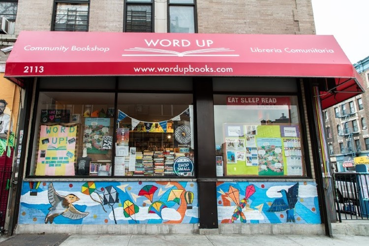 A bookstore with a red awning that says "Word Up Community Bookstore/Libreria Communitaria."