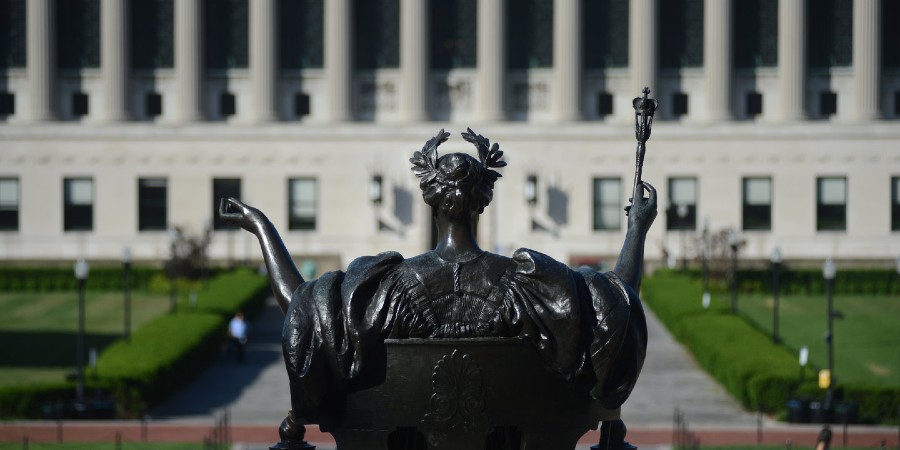 A view of the Columbia Alma Mater statue from behind, looking out over College Walk and Butler Library.
