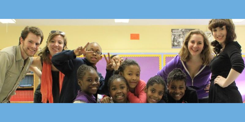 Children and student artists smiling for a group photo