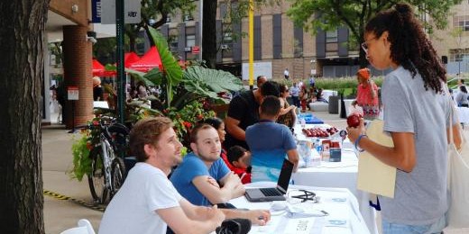 students on sidewalk with tables