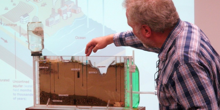 An older man manipulates a scientific display.