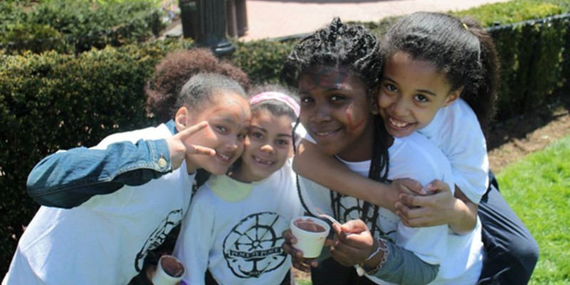 Four young girls in Peace by PEACE t-shirts.