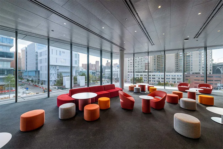 Orange and red couches in a window lit room.