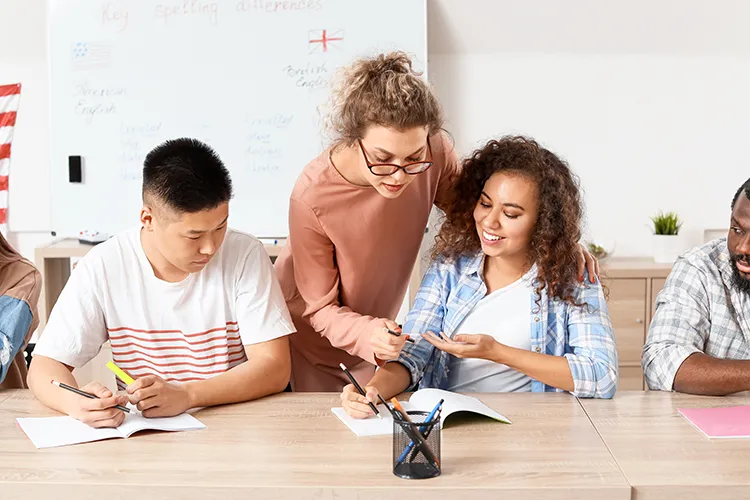 A teacher works with students on language. 