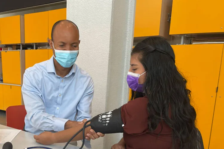 Man takes the blood pressure of a woman. 