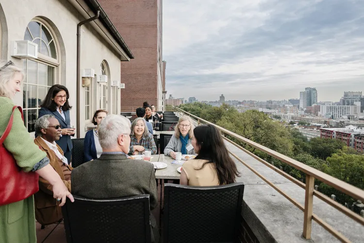 President Shafik speaks to a group of community residents on the patio of Faculty House over looking Morningside Park.