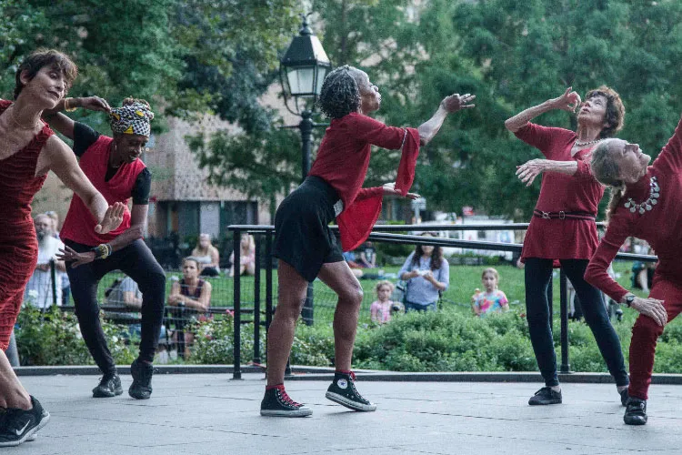 Instructor leading seniors through an outdoor dance class. 