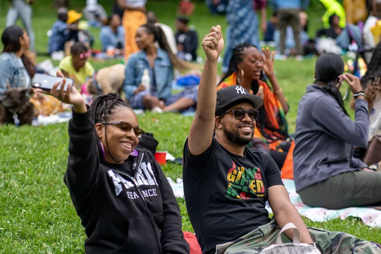 Two festival-goers hanging out at the park during Good Vibes in the Park. 