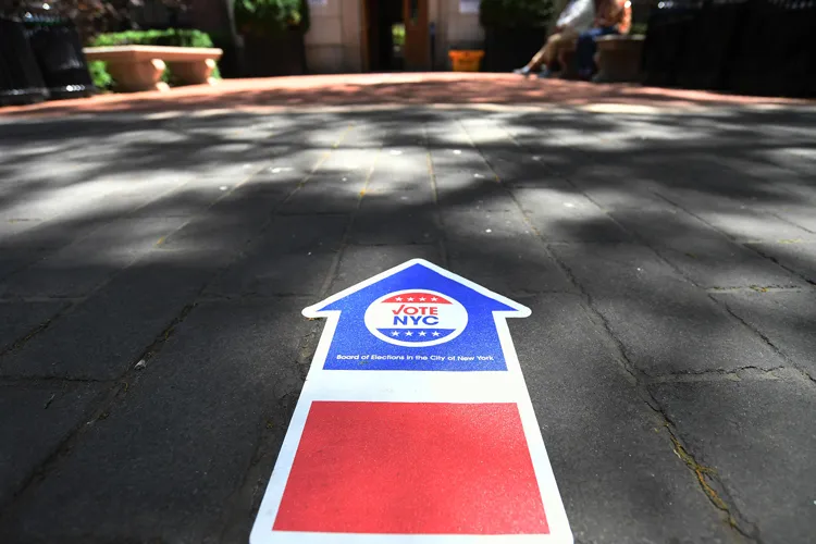 Red, white, and blue arrow on the sidewalk pointing towards Wien Hall at Columbia University, one of the early voting locations for the primary election. 