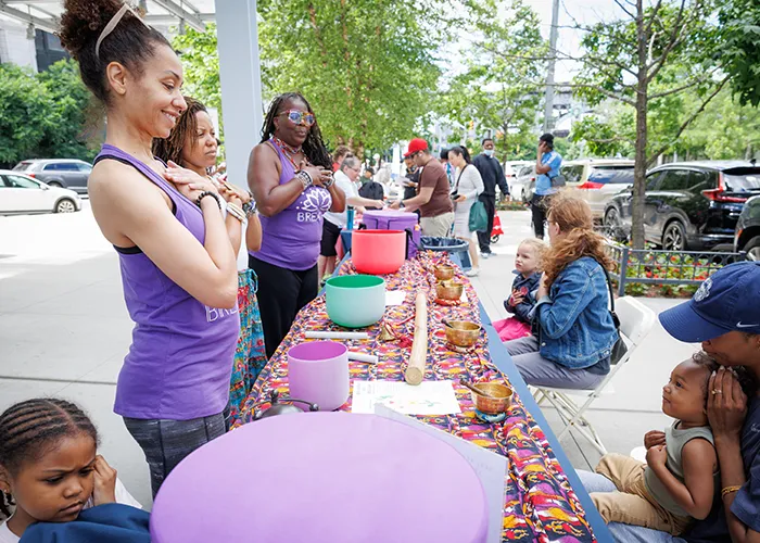 A meditation group works with kids and families on tibetan bowls.