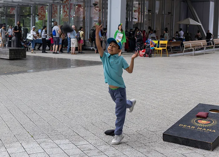 A kid plays cornhole while attendees stop by for tasty treats at Lenfest Center for the Arts. 