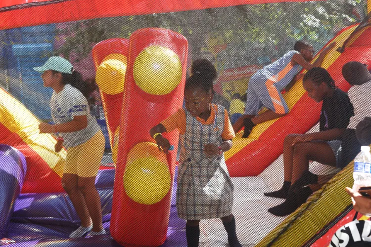 Youth play in a bouncy house during the annual back-to-school event in West Harlem. Photo credit: Susan Farley