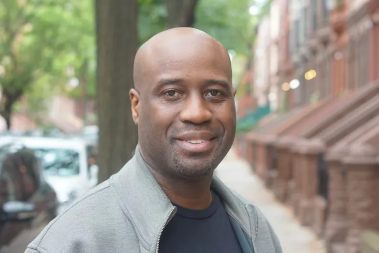A close-up of multimedia artist Bayeté Ross Smith standing in a New York City street