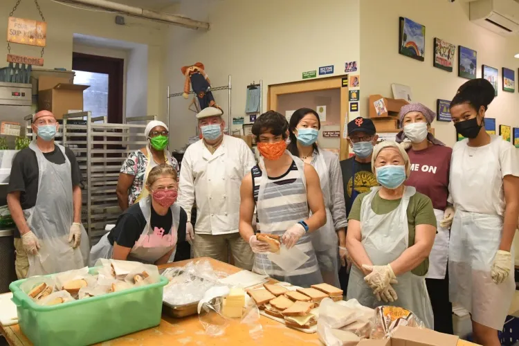 Group of volunteers gathered for a photo in a soup kitchen
