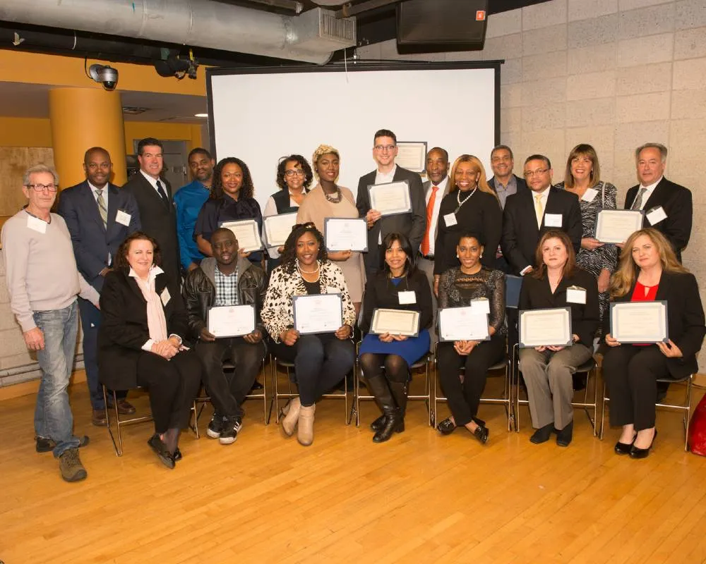 A group of adults, seated and standing, with their completion certificates for the CU Grow program.